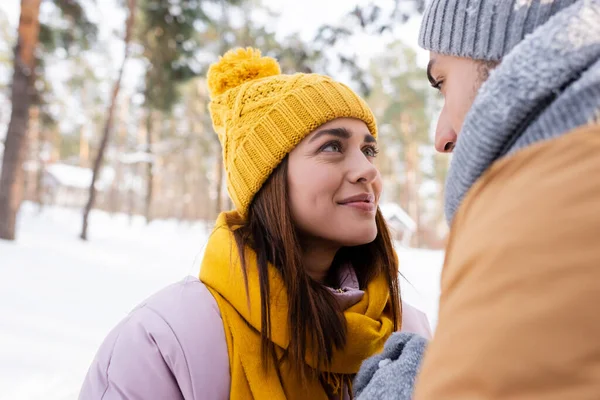 Lächelnde Frau schaut Freund im Winterpark an — Stockfoto