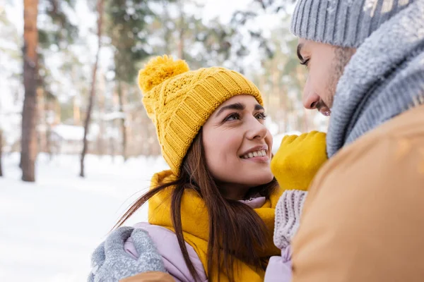 Sonriente hombre abrazando novia en invierno traje al aire libre - foto de stock