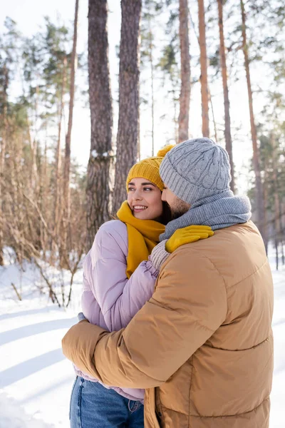 Man embracing girlfriend in winter park — Stock Photo