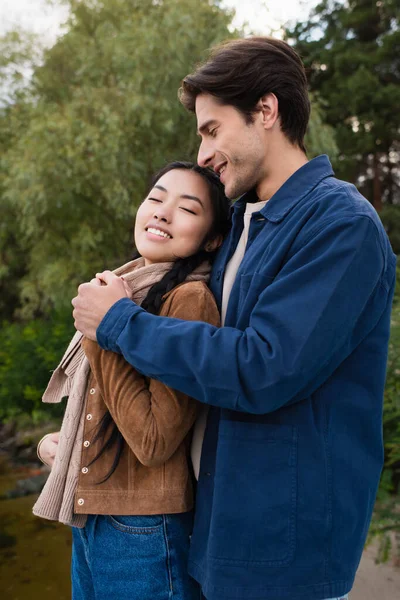 Man hugging asian girlfriend outdoors during weekend — Stock Photo