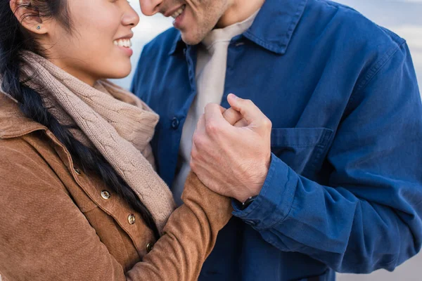 Cropped view of smiling couple holding hands outdoors — Stock Photo