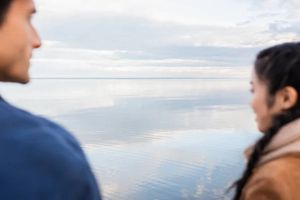 Sea and blurred interracial couple on foreground — Stock Photo