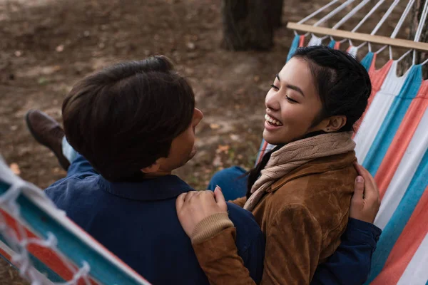 Asian woman hugging boyfriend in blurred hammock during vacation — Stock Photo