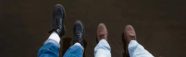 Vista dall'alto delle gambe della coppia sopra l'acqua del lago all'aperto, banner — Foto stock