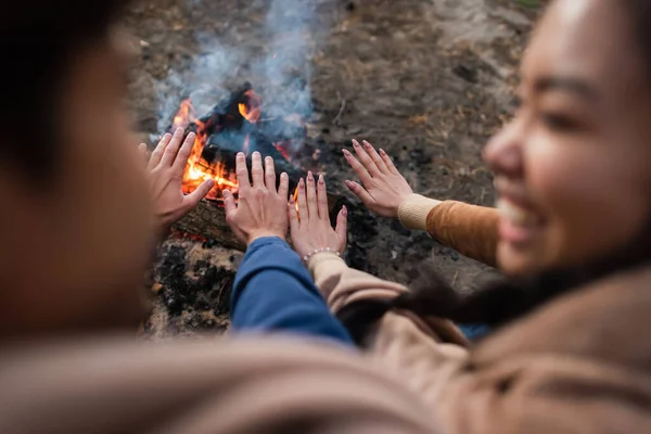 Couple flou se réchauffant les mains près du feu de camp pendant le week-end — Photo de stock