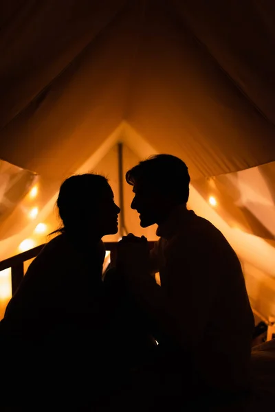 Vue latérale des silhouettes de couple dans la maison de glamping dans la nuit — Photo de stock