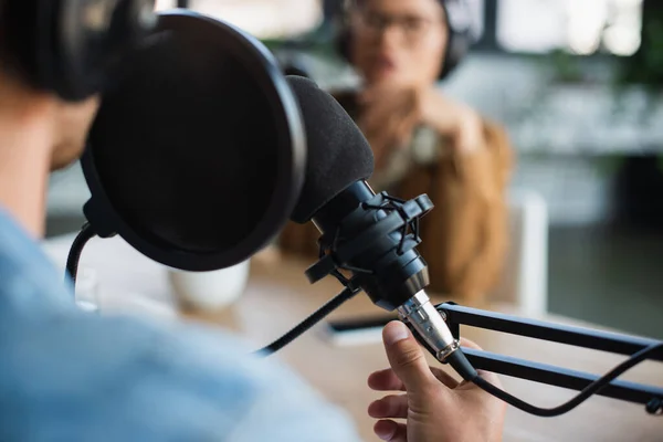 Vista ritagliata di conduttore radio offuscata parlare in studio — Foto stock