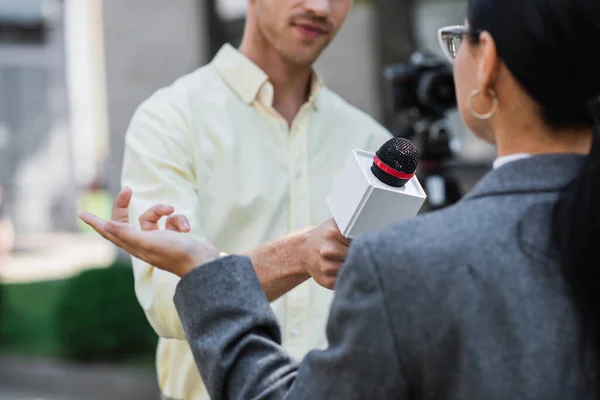 Розмитий репортер тримає мікрофон біля розмитої бізнес-леді — стокове фото