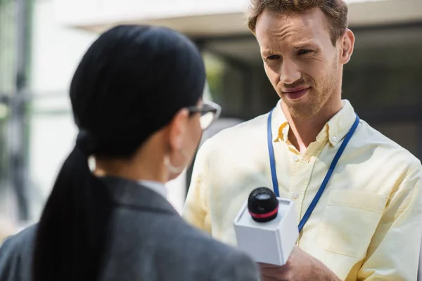 Reporter taking interview with blurred businesswoman in glasses — Stock Photo