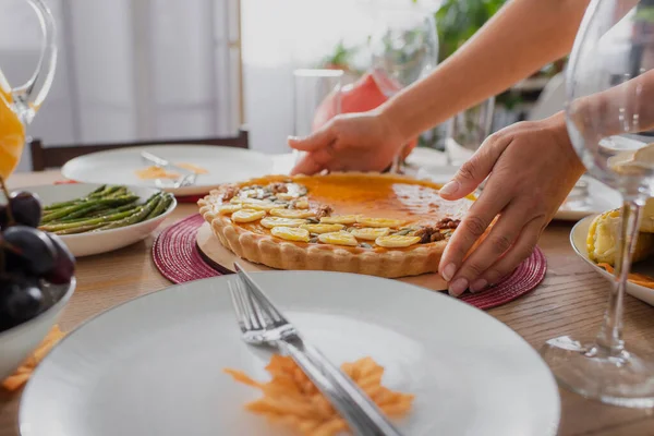 Vista recortada de la mujer afroamericana poniendo sabroso pastel en la mesa cerca de la cena de acción de gracias — Stock Photo