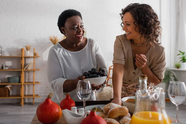 Afro-americana mãe e filha adulta servindo jantar de ação de graças juntos — Fotografia de Stock