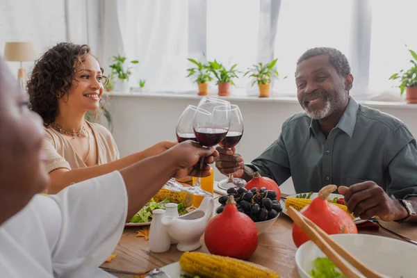 Lächelnde afrikanisch-amerikanische Familie stößt beim Erntedank-Dinner auf Wein an — Stockfoto