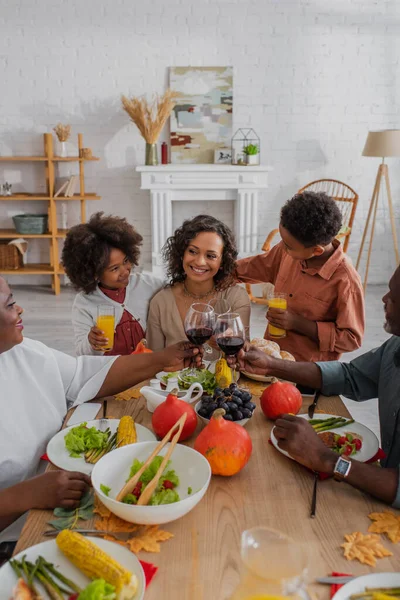 Sonriente familia afroamericana celebrando Acción de Gracias juntos en casa - foto de stock