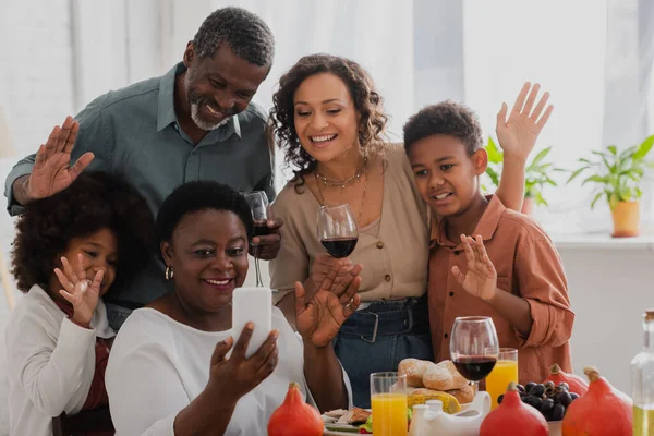 Smiling african american family taking selfie on smartphone during thanksgiving celebration — Stock Photo