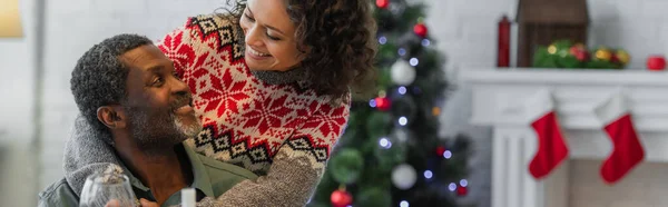 Fröhlich afrikanisch-amerikanischer Vater und Tochter lächeln sich während der Weihnachtsfeier an, Banner — Stockfoto