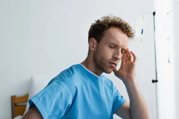 Patient with closed eyes suffering from headache in hospital — Stock Photo