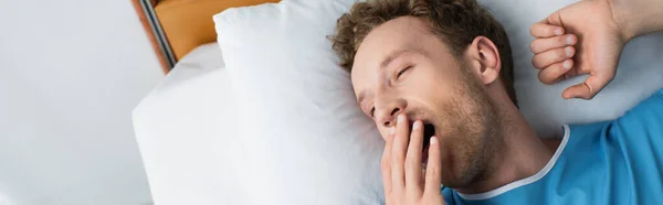 Top view of patient yawning while lying in hospital bed, banner — Stock Photo