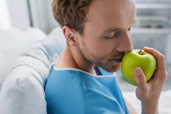 Paciente com olhos fechados cheirar maçã verde no hospital — Fotografia de Stock