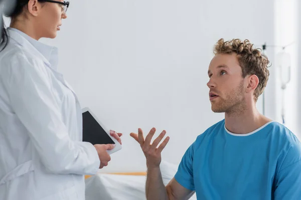 Терпеливый жест во время разговора с врачом в белом халате — стоковое фото