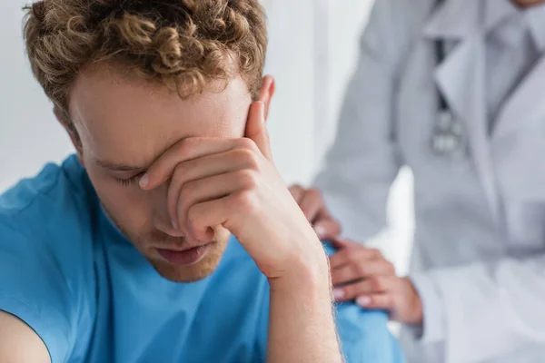 Doctor in white coat calming frustrated patient in hospital — Stock Photo