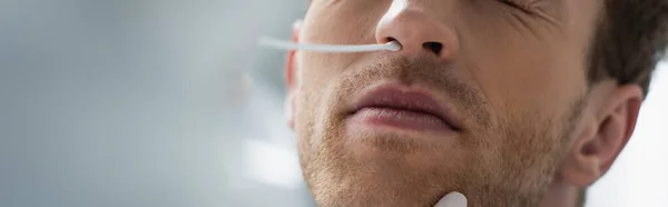 Cropped view of doctor holding swab near nose of patient while doing pcr test, banner — Stock Photo