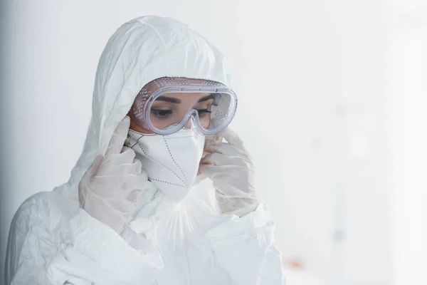 Medico in dispositivi di protezione individuale e occhiali protettivi guardando in basso — Foto stock