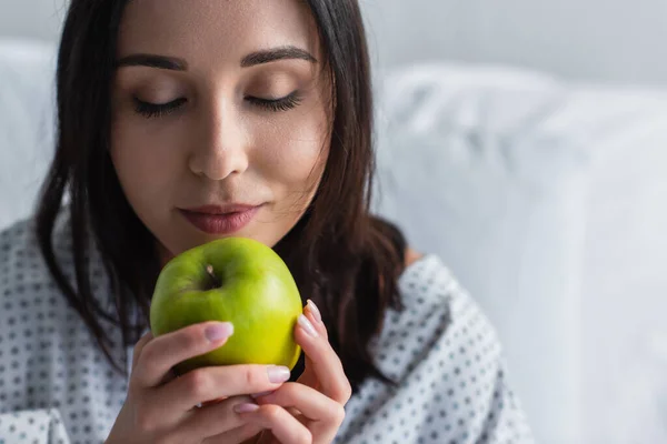 Morena mujer sosteniendo fresca manzana en las manos - foto de stock