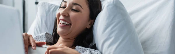 Mujer alegre viendo la película de comedia en el ordenador portátil, bandera - foto de stock