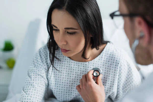 Médecin flou dans les lunettes examen brunette patient à l'hôpital — Photo de stock