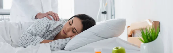 Médico despertar morena paciente en cama de hospital, pancarta - foto de stock