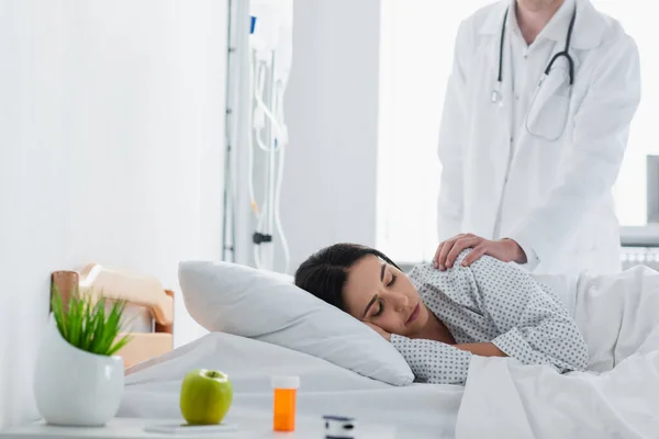 Médico acordar paciente morena na cama do hospital — Fotografia de Stock