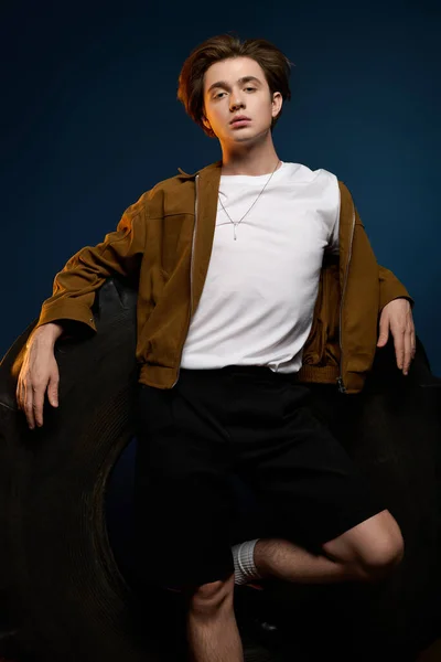 Красивый молодой человек без усилий позирует в модном наряде, демонстрируя современный стиль и уравновешенность. — стоковое фото