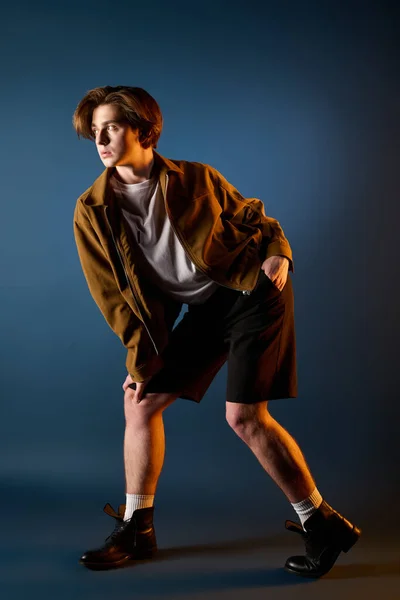 Bonito jovem posa confiantemente em trajes elegantes, apresentando tendências da moda moderna. — Fotografia de Stock