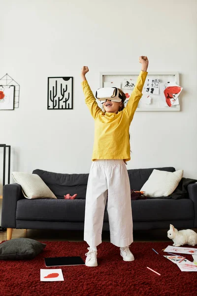Ein fröhliches Mädchen beschäftigt sich zu Hause mit Virtual-Reality-Inhalten und feiert ihren Sieg. — Stockfoto