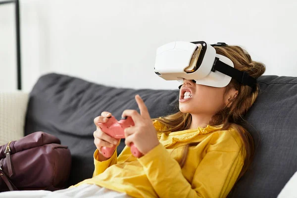 Una chica alfa gen totalmente comprometido en un juego de realidad virtual en casa en su traje acogedor. - foto de stock