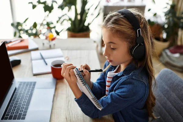 Eine Generation Alpha-Mädchen konzentriert sich an einem Holztisch auf ihre Zeichnung. — Stockfoto