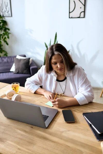 In her cozy home office, a woman diligently works on freelance projects, showcasing creativity. — Stock Photo