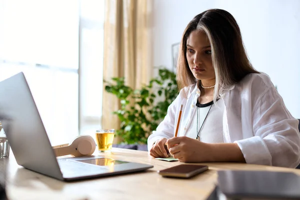 Женщина с уникальным белым хоботом работает за своим столом, сосредоточившись на своих задачах.. — стоковое фото