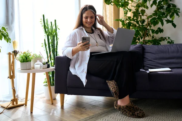 A woman with Waardenburg Syndrome works from home, smiling while using her phone. — Stock Photo