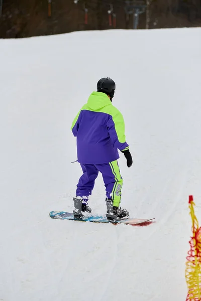 Ein Mann genießt das Snowboarden auf einem unberührten schneebedeckten Hang bei winterlicher Kälte. — Stockfoto