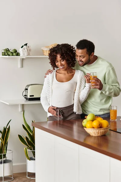 Pareja feliz disfruta de un momento acogedor en casa mientras celebran su viaje de embarazo juntos. - foto de stock