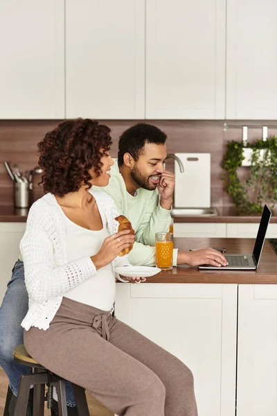 Ein glückliches Paar genießt die Gesellschaft des anderen zu Hause und freut sich auf das bevorstehende Baby. — Stockfoto