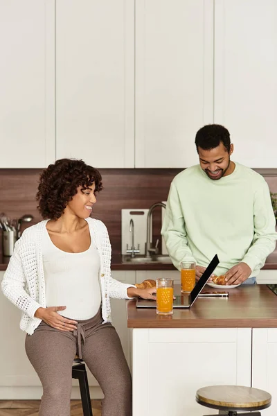 Una coppia afroamericana felice si gode la colazione a casa mentre si prepara per il loro bambino. — Foto stock