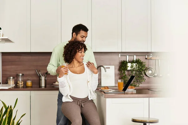 Felice coppia gode di un momento accogliente nella loro cucina, celebrando la loro gravidanza e l'amore. — Foto stock