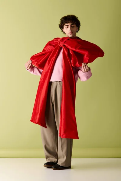 Un hombre con estilo muestra con confianza su atuendo, con un acento rojo audaz. - foto de stock