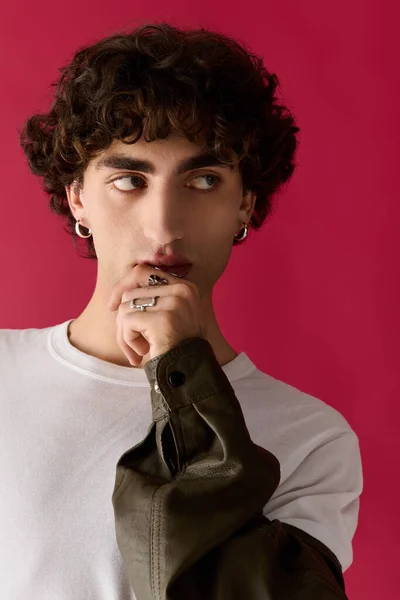 Стильный мужчина с вьющимися волосами уверенно позирует, источая очарование и очарование. — стоковое фото