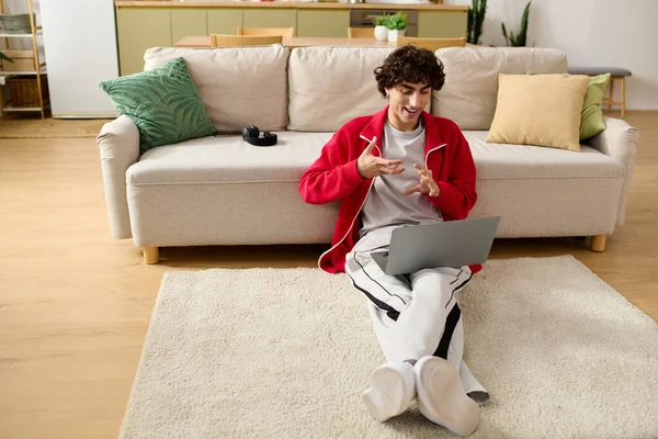 Casual conversation happens as a well dressed man sits comfortably on the floor using a laptop. — Stock Photo