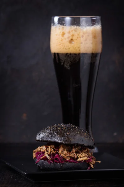 Black burger with dark beer — Stock Photo, Image