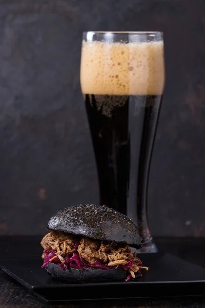 Black burger with dark beer — Stock Photo, Image