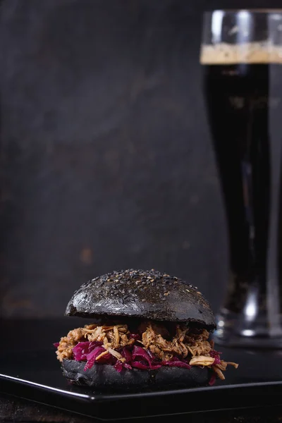 Schwarzer Burger mit dunklem Bier — Stockfoto